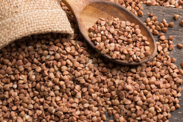 Buckwheat groats on wooden background. Healthy cereal concept.  