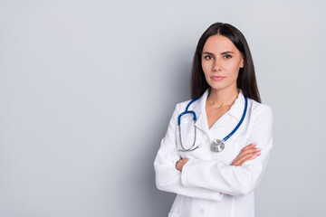 Photo of calm surgeon focused lady folded arms empty space banner isolated on grey color background