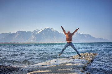 happy man jump in the air at switzerland lake