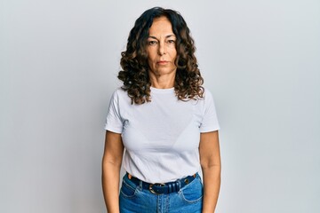 Middle age hispanic woman wearing casual white t shirt skeptic and nervous, frowning upset because of problem. negative person.