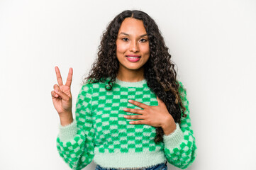 Young hispanic woman isolated on white background taking an oath, putting hand on chest.