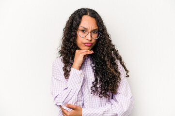 Young hispanic woman isolated on white background suspicious, uncertain, examining you.