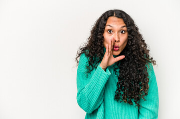 Young hispanic woman isolated on white background is saying a secret hot braking news and looking aside