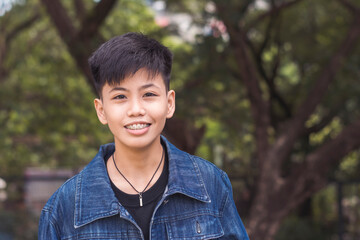 A cute young man in happy thoughts. Delighted about the compliments about him. Standing outside the...