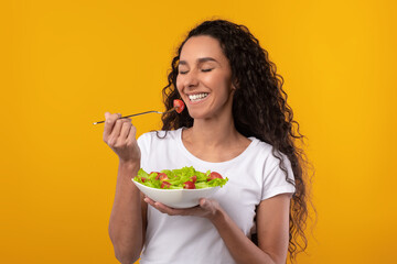 Portrait of Smiling Latin Lady Holding Plate With Salad