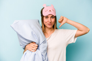 Young caucasian woman wearing a pajama isolated on blue background feels proud and self confident,...