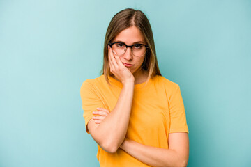 Young caucasian woman isolated on blue background who is bored, fatigued and need a relax day.