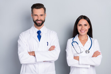 Photo of two positive intelligent therapist folded arms toothy smile look camera isolated on grey...