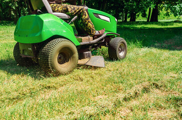 Obraz premium Mowing grass in the park. Lawn mower. Lawn care.