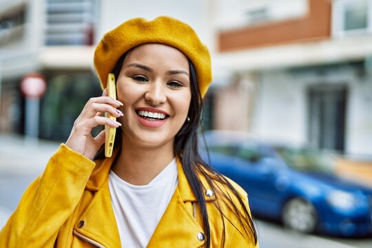 Young latin girl smiling happy talking on the smartphone at the city.