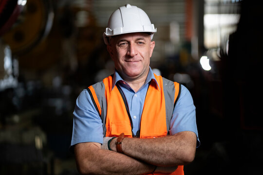 Smart portrait, male senior engineer standing with his arms crossed confidently.