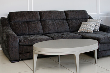 A soft modern sofa with a wooden coffee table in the living room. Interior design concept.
