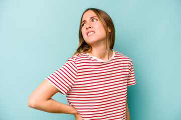 Obraz premium Young caucasian woman isolated on blue background suffering a back pain.