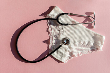 Womens underwear and stethoscope. Concept of menopause and critical days, abdominal pain. Menstrual cycle, womens health, gynecology.