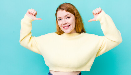 pretty red head woman feeling proud, arrogant and confident, looking satisfied and successful,...