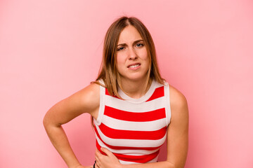 Young caucasian woman isolated on pink background having a liver pain, stomach ache.