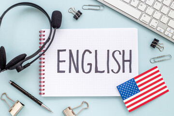 English lessons concept. Headpones with notebook on student table desk