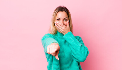 pretty blonde woman laughing at you, pointing to camera and making fun of or mocking you
