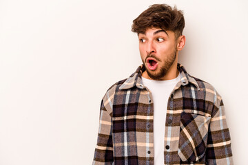 Young hispanic man isolated on white background being shocked because of something she has seen.