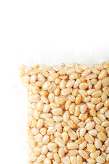 Kernels of peeled pine nuts in vacuum packaging on a white background