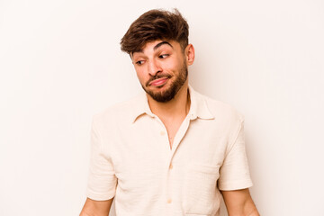 Young hispanic man isolated on white background shrugs shoulders and open eyes confused.