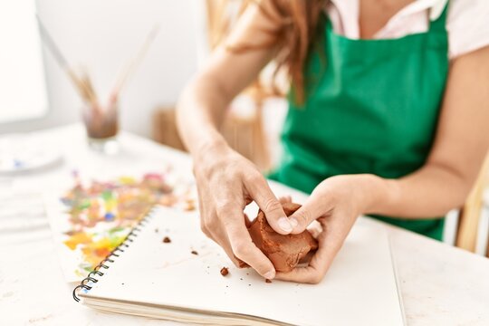 Middle age hispanic woman make ceramics at art studio