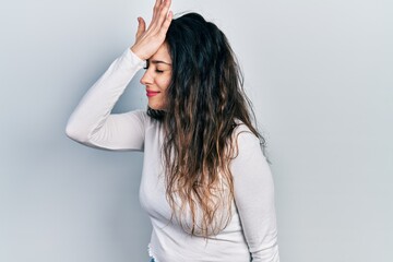 Fototapeta premium Young hispanic woman wearing casual clothes surprised with hand on head for mistake, remember error. forgot, bad memory concept.