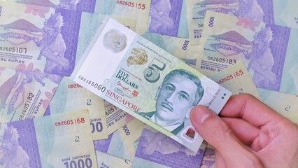 Businessman's hand holding Singapore Dollar Banknotes. Business Investment Economy Saving Loan Income Money and Finance concept. Prosperity concept. Five SGD . 5 SGD. Money Background.