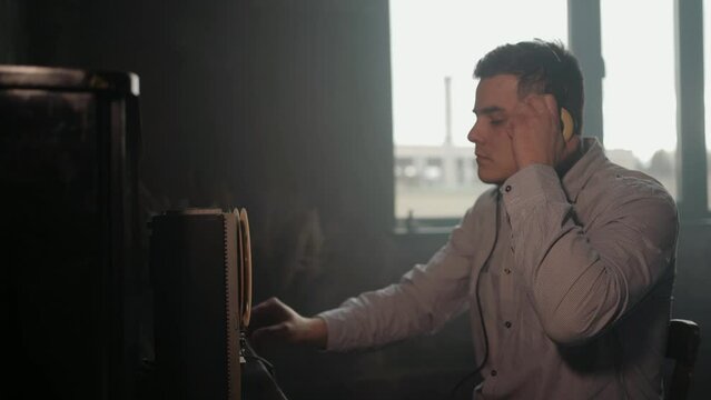 Special agent listens on the reel tape recorder. Officer wiretapping in headphones. KGB spying of conversations.