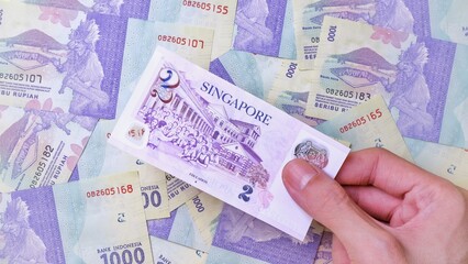 Businessman's hand holding Singapore Dollar Banknotes. Business Investment Economy Saving Loan Income Money and Finance concept. Prosperity concept. Two SGD . 2 SGD. Money Background.