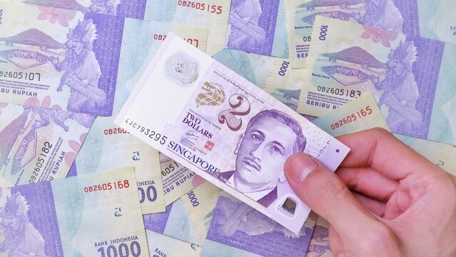 Businessman's hand holding Singapore Dollar Banknotes. Business Investment Economy Saving Loan Income Money and Finance concept. Prosperity concept. Two SGD . 2 SGD. Money Background.