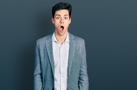 Young hispanic man wearing business clothes afraid and shocked with surprise and amazed expression, fear and excited face.