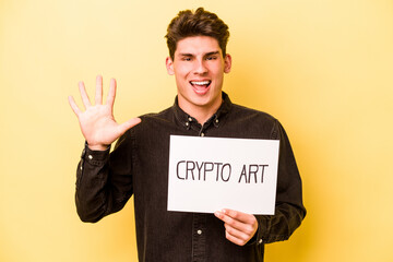 Young caucasian man holding crypto art placard isolated on yellow background smiling cheerful showing number five with fingers.