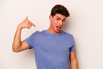Fototapeta premium Young caucasian man isolated on white background person pointing by hand to a shirt copy space, proud and confident