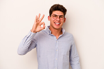 Naklejka premium Young caucasian man isolated on white background cheerful and confident showing ok gesture.