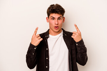 Young caucasian man isolated on white background pointing upside with opened mouth.