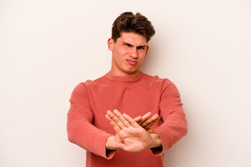 Young caucasian man isolated on white background doing a denial gesture