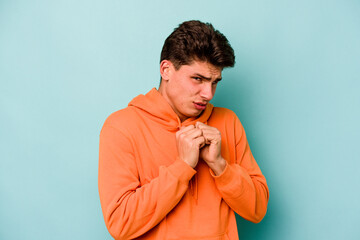 Young caucasian man isolated on blue background scared and afraid.