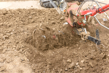 Small farm tractor plows the ground, the work of a walk-behind tractor