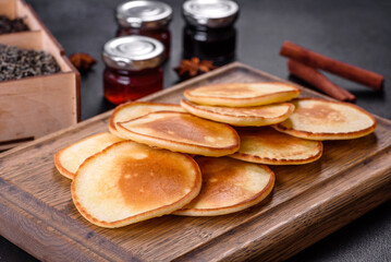 Delicious fresh pancakes on a wooden cutting board with sugar