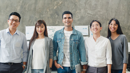 Portrait of successful creative businessman and businesswoman smart casual wear looking at camera and smiling in modern office workplace. Diverse Asia male and female standing together at startup.