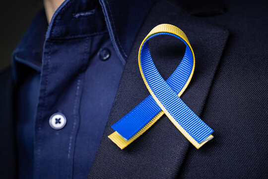 Blue and yellow ribbon for Ukraine on the suit lapel