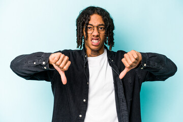 Young African American man isolated on blue background showing thumb down and expressing dislike.