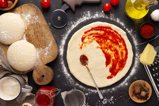 Pizza and sauce homemade cooking with ingredients on table. Dough pizza at tabletop