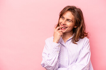 Young caucasian woman isolated on pink background relaxed thinking about something looking at a copy space.