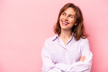Fototapeta premium Young caucasian woman isolated on pink background smiling confident with crossed arms.