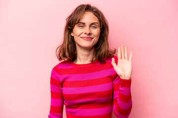 Fototapeta na wymiar Young caucasian woman isolated on pink background smiling cheerful showing number five with fingers.
