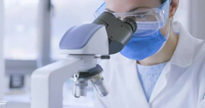 Young researcher analyzing samples under a microscope