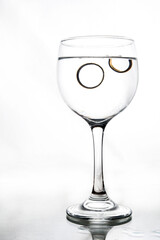 glass cup with white wine inside glass with water isolated on white background
