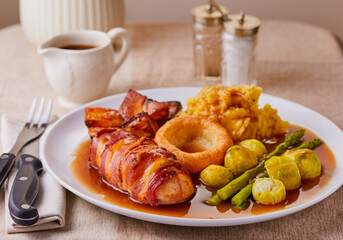 Chicken breast wrapped in bacon,roast dinner with gravy.